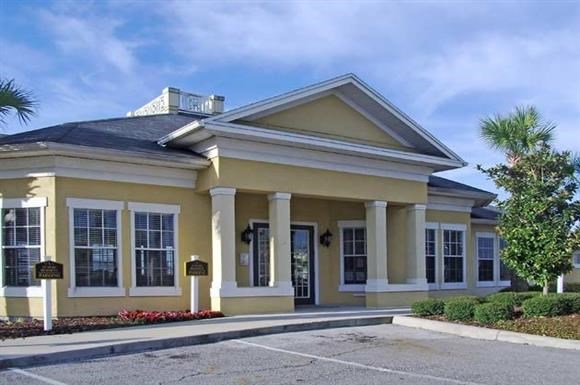 the front of a yellow building with columns