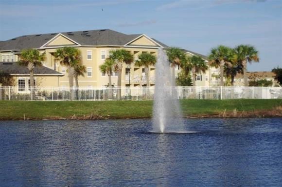 a fountain in the water in front of a building