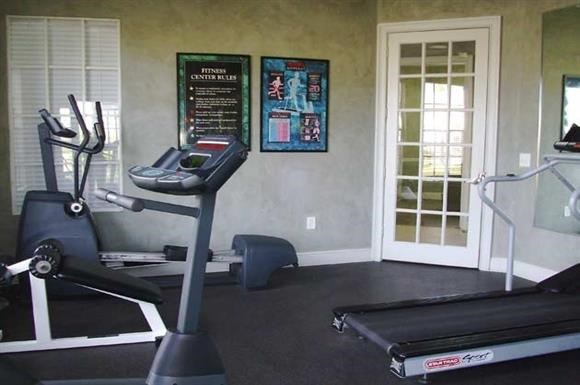 a gym with a treadmill and a window