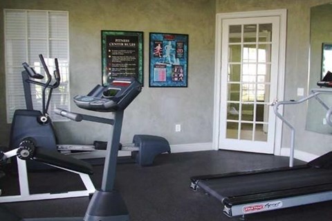 a gym with a treadmill and a window