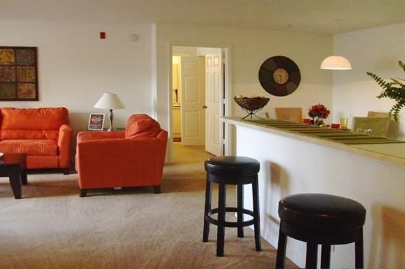a living room with a bar and some chairs