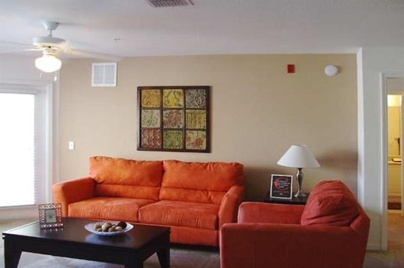 a living room with a orange couch and a coffee table