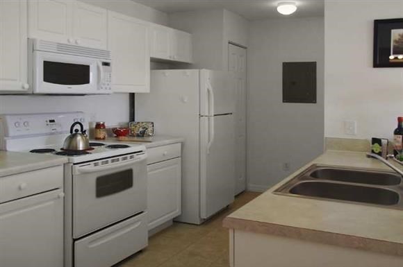 a kitchen with white appliances and a sink
