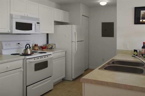 a kitchen with white appliances and a sink
