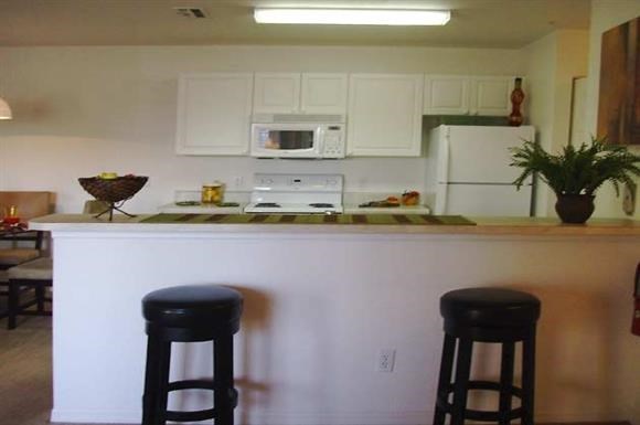 a kitchen with two stools in front of a counter