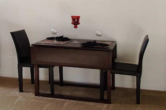 a table with two wine glasses and two chairs