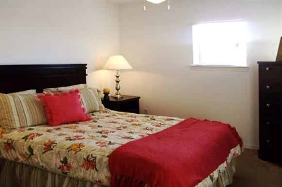 a bedroom with a bed with a red blanket