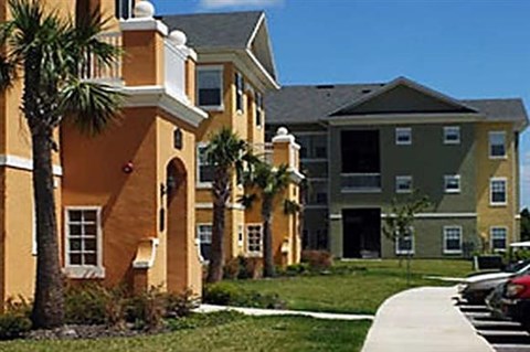 an apartment building with palm trees in front of it