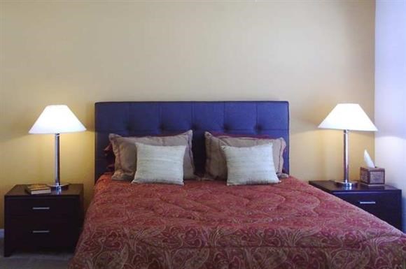 a bedroom with a bed and two lamps