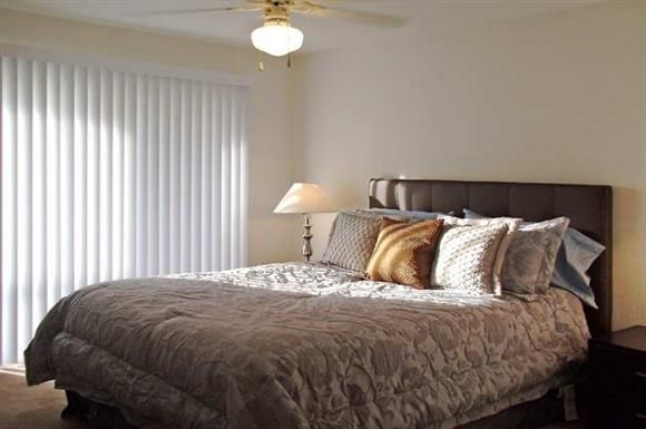 a bedroom with a bed and a ceiling fan