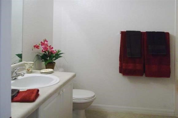 a bathroom with a sink toilet and two towels