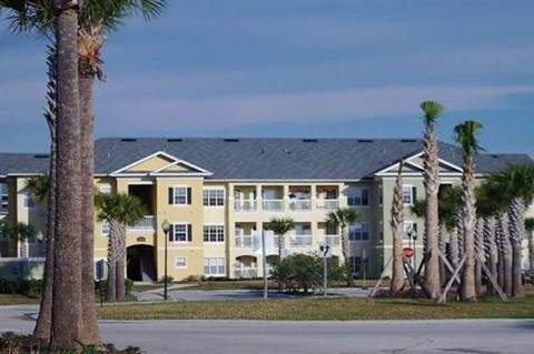 a large building with palm trees in front of it