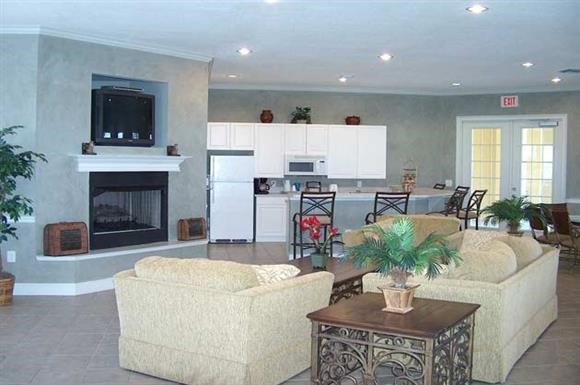 a living room with a fireplace and a kitchen