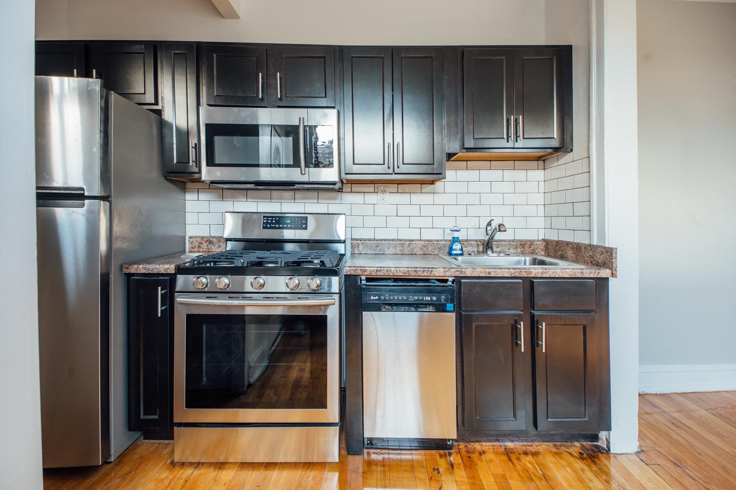 a kitchen with stainless steel appliances and black cabinets