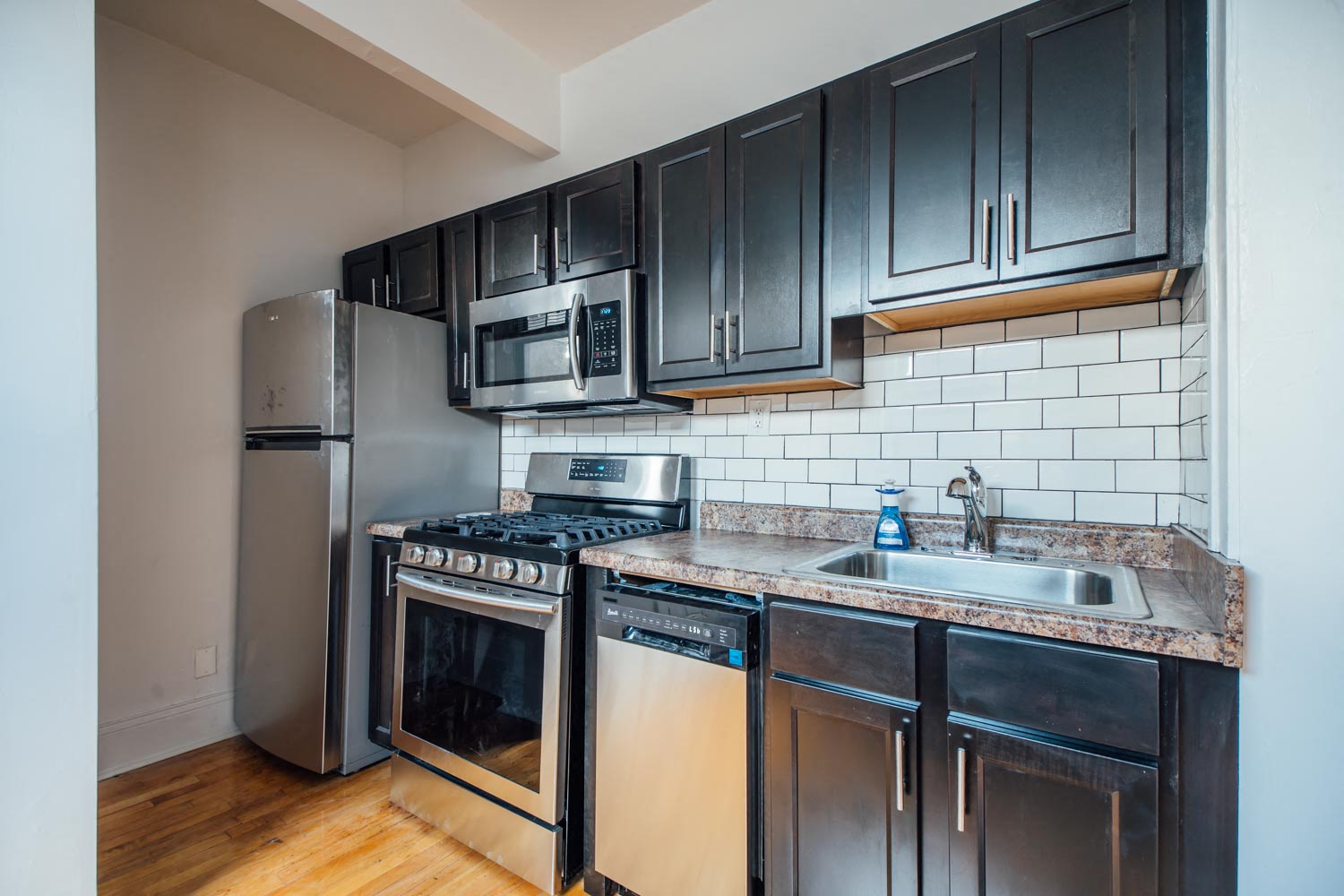 a kitchen with stainless steel appliances and black cabinets