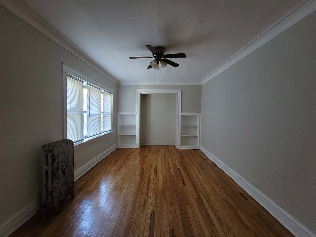 a living room with wood floors and a ceiling fan