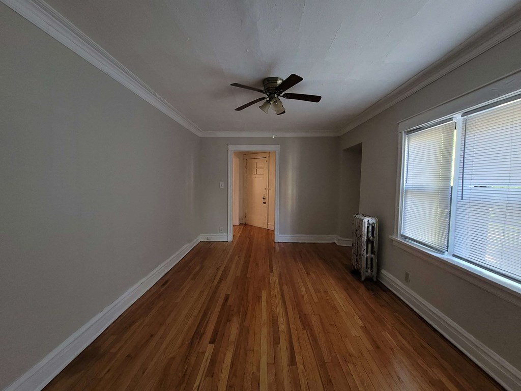 a living room with wood floors and a ceiling fan