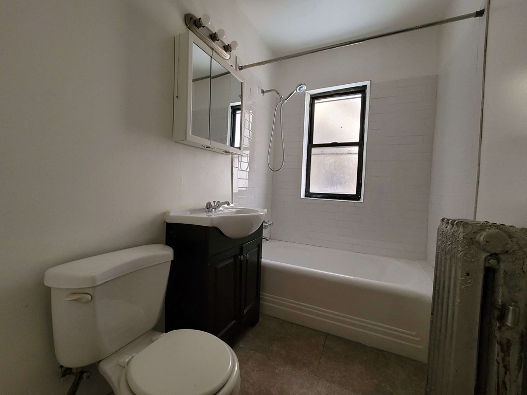 a bathroom with a toilet and a sink and a bath tub