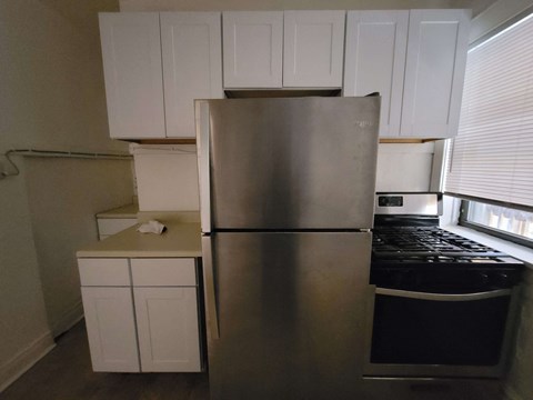 a kitchen with a stainless steel refrigerator and white cabinets