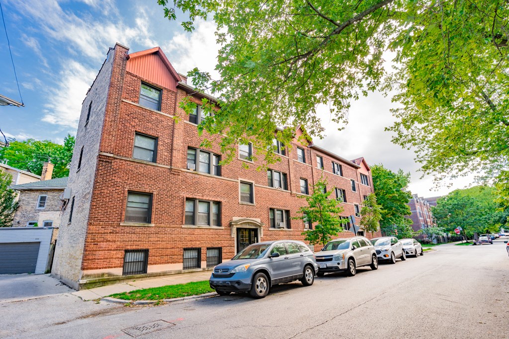 a brick building with cars parked in front of it on a street