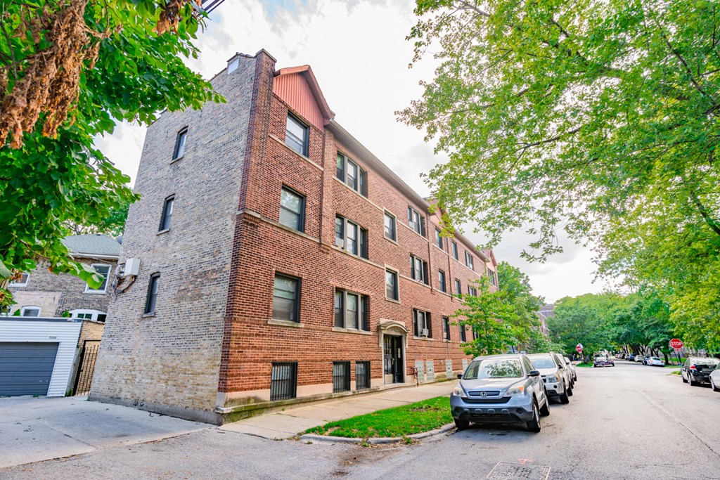 a brick building with cars parked in front of it on a street