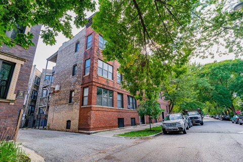 a red brick building on a city street with cars parked
