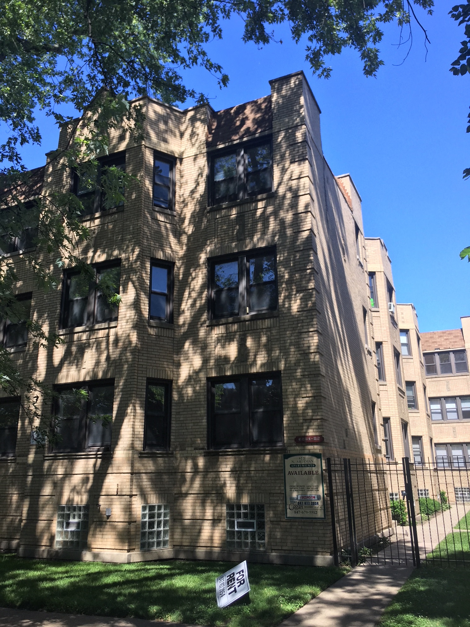 a tall brick building with a fence in front of it