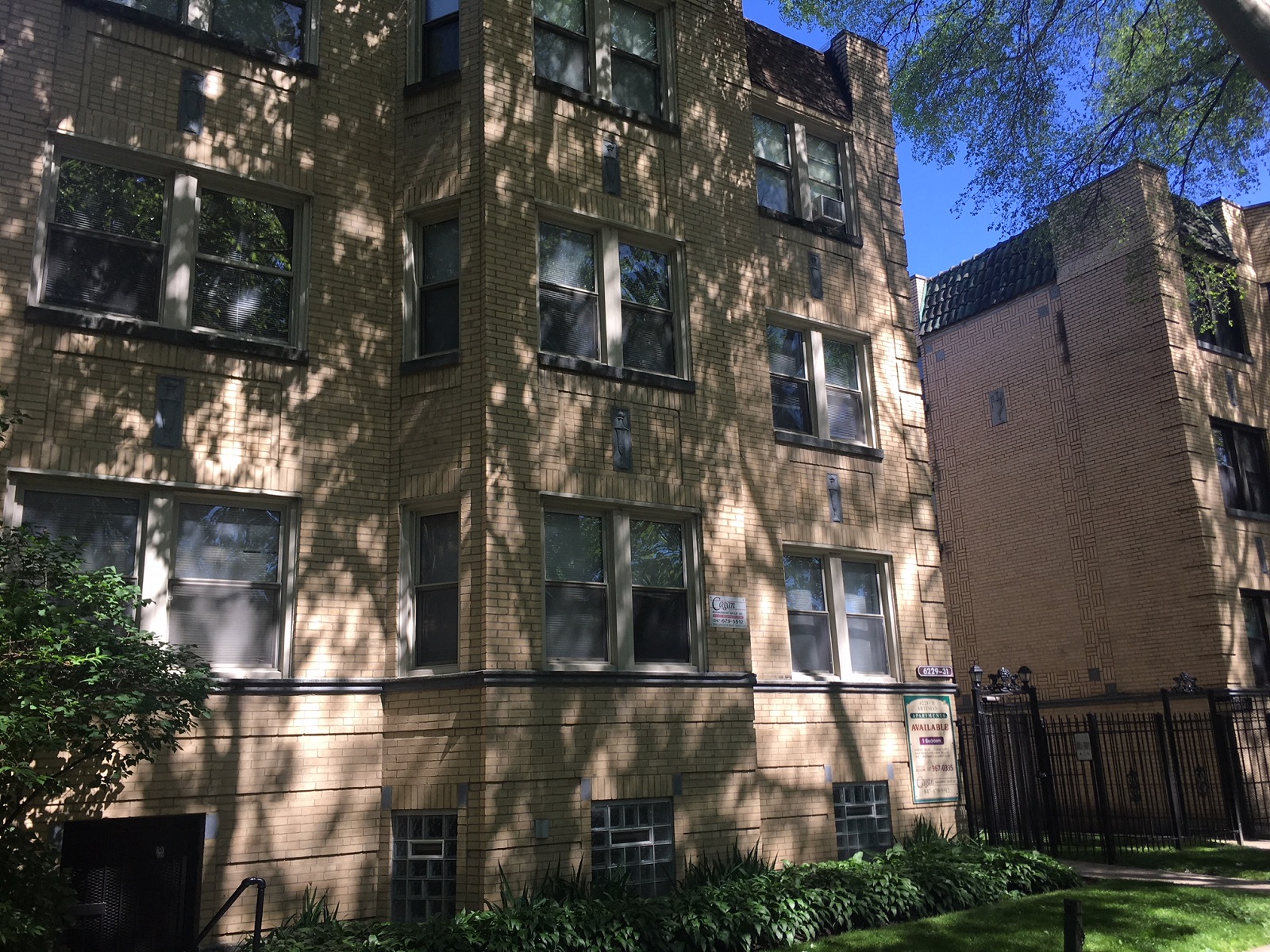 the exterior of a brick apartment building with shadows on it