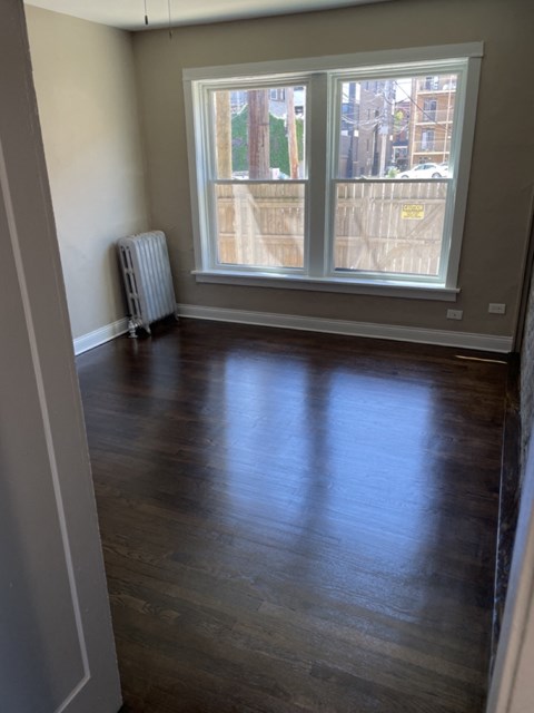 a room with a hard wood floor and a large window