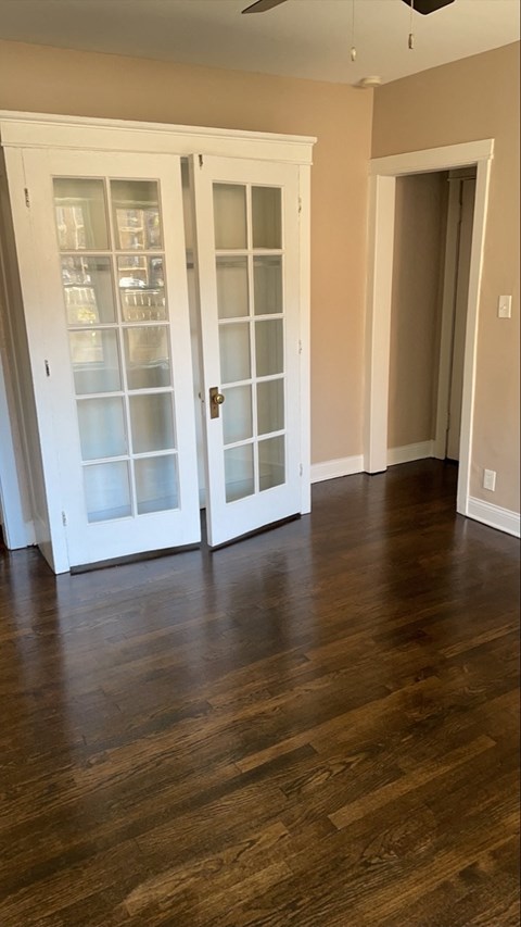 an empty living room with a hard wood floor and doors