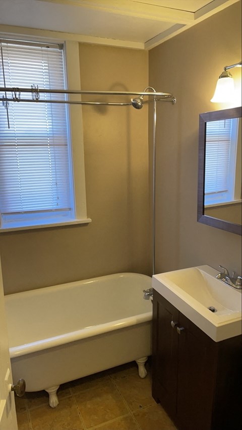 a bathroom with a tub and a sink and a window