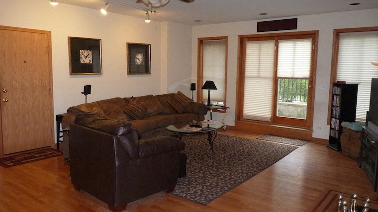 a living room with a leather couch and a wooden floor