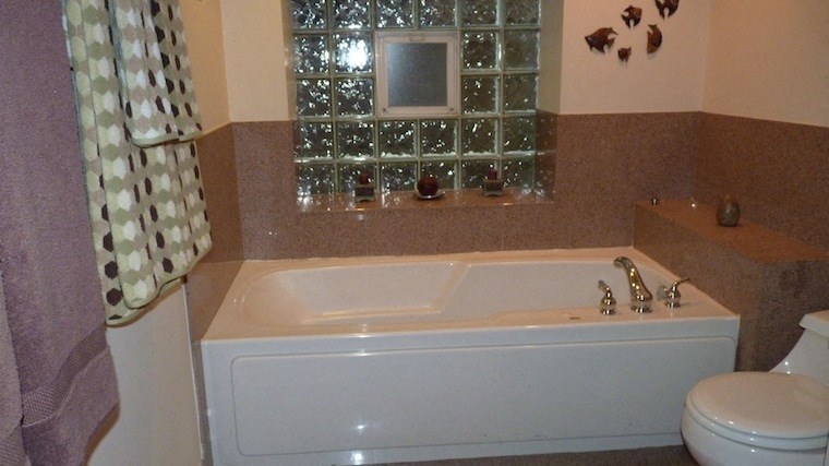 a bathroom with a white tub and a window