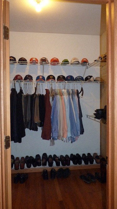 a closet with a rack of clothes and shoes in it