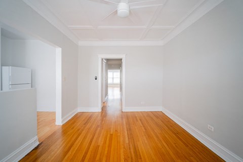 a living room with white walls and wooden floors