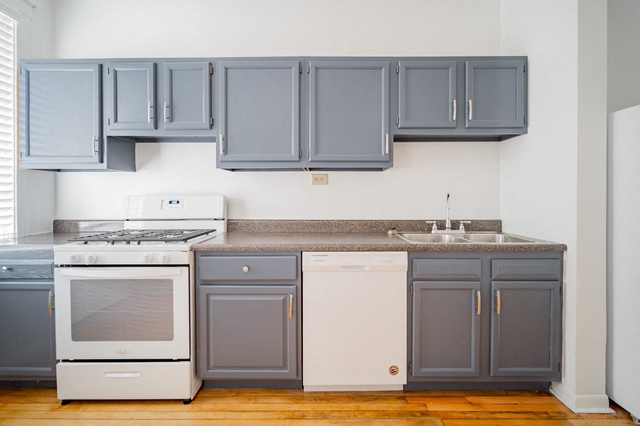 a kitchen with blue cabinets and white appliances