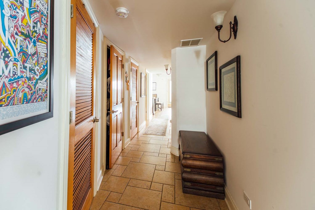 a hallway with wooden doors and a bench