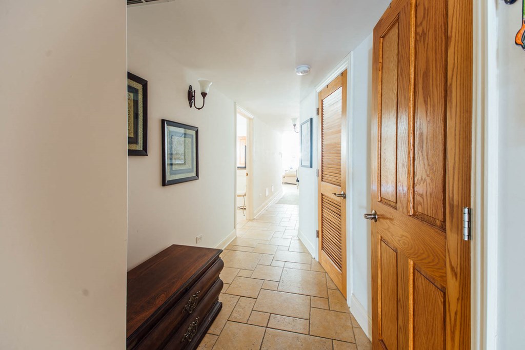 a hallway with a wooden door and a wooden bench
