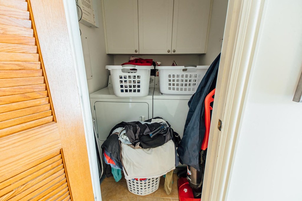 a laundry room filled with clothes and baskets in it