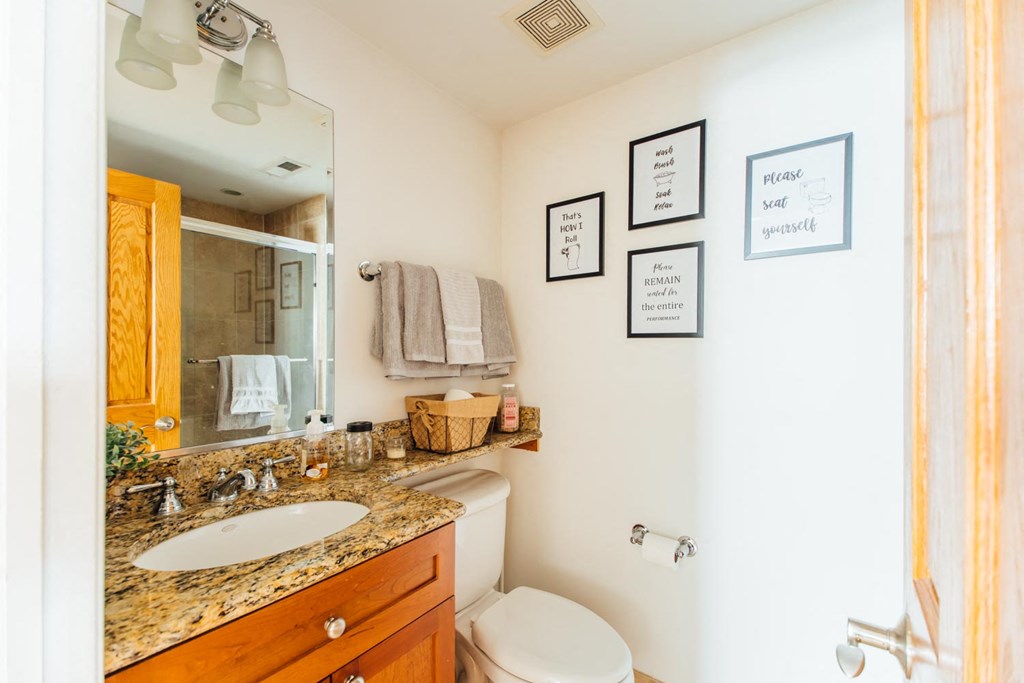 a bathroom with a sink toilet and a mirror