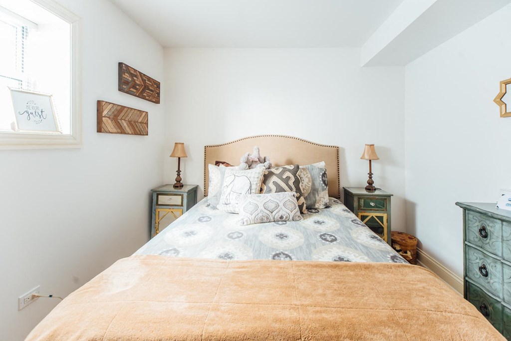 a bedroom with a bed and two night stands and a window