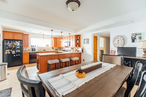 a dining room table with a kitchen in the background