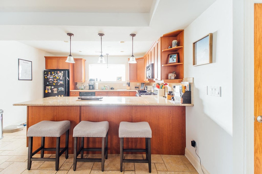 a kitchen with a counter and three stools