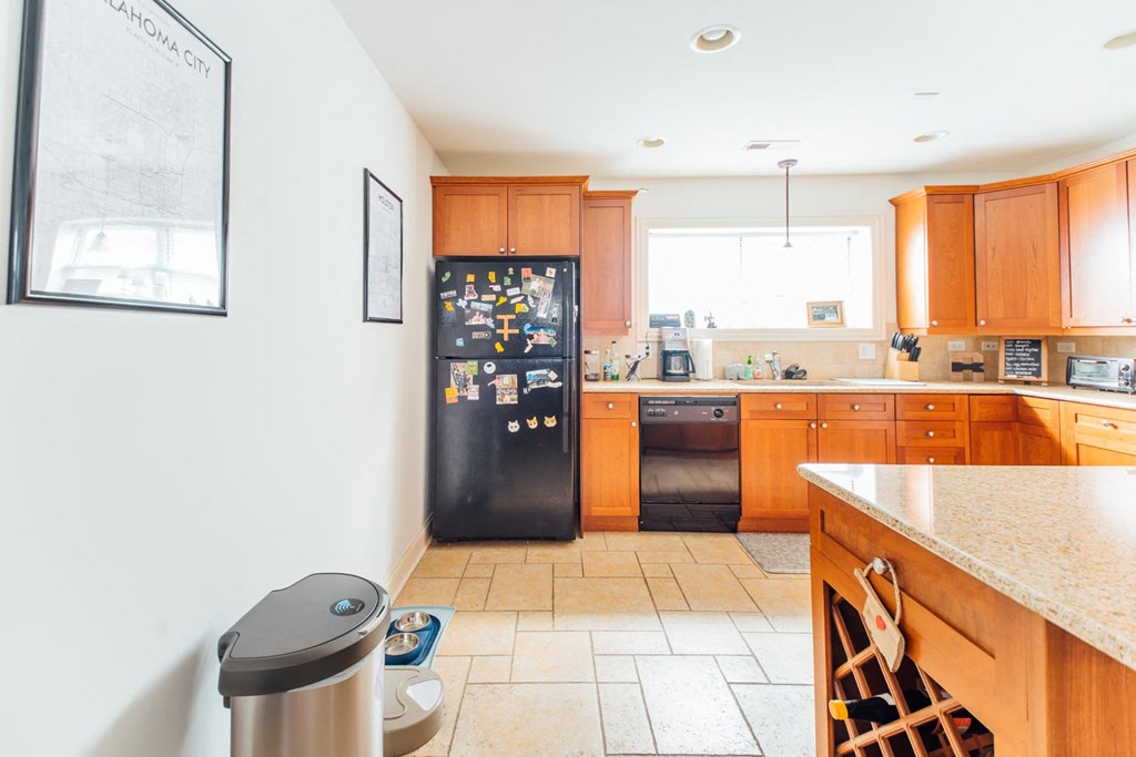 a kitchen with wooden cabinets and a black refrigerator
