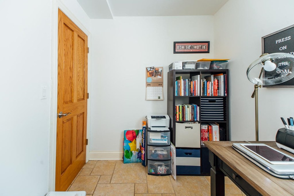 a home office with a desk and a bookshelf