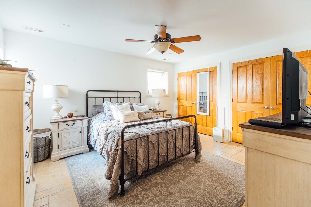 a bedroom with a bed and a ceiling fan