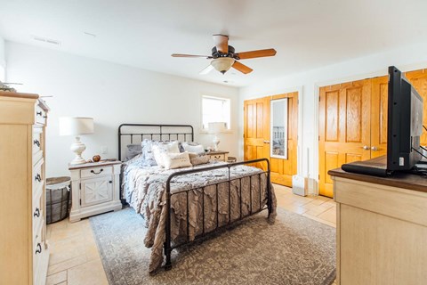 a bedroom with a bed and a ceiling fan