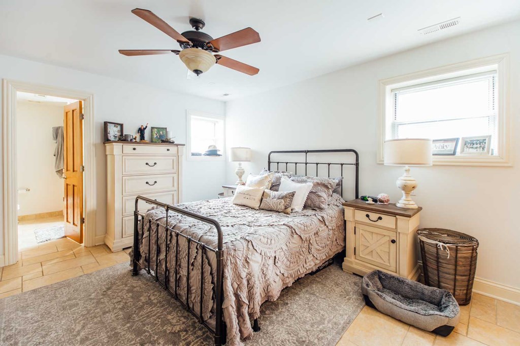 a bedroom with a bed and a ceiling fan