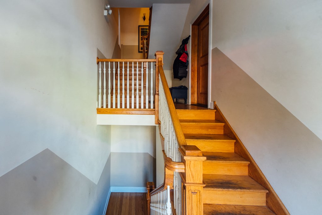a staircase in a home with wooden stairs and white walls
