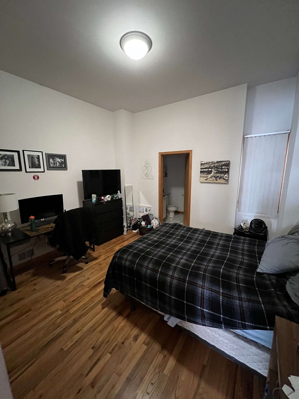a bedroom with a bed and a wooden floor